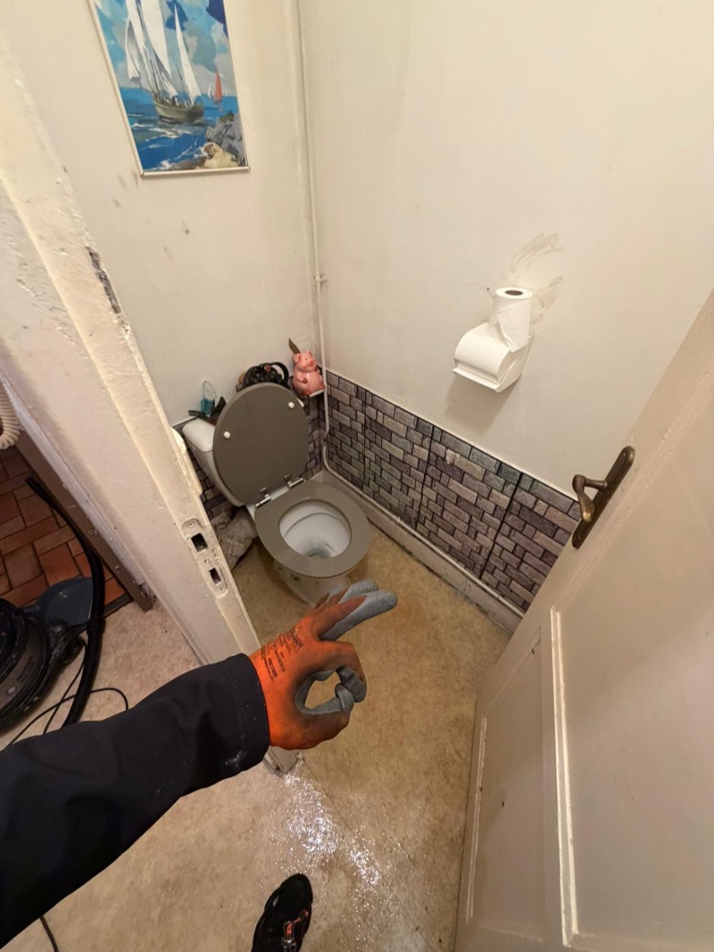 Technicien fait signe OK après débouchage WC